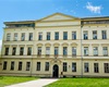 Historická budova školy s&nbsp;nástavbou (prosklený prstenec v&nbsp;horním patře)